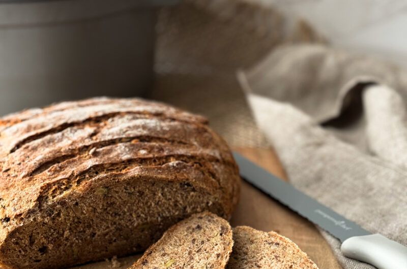 Vollkornbrot, Hülsenfrüchte und Beeren auf Holzbrett